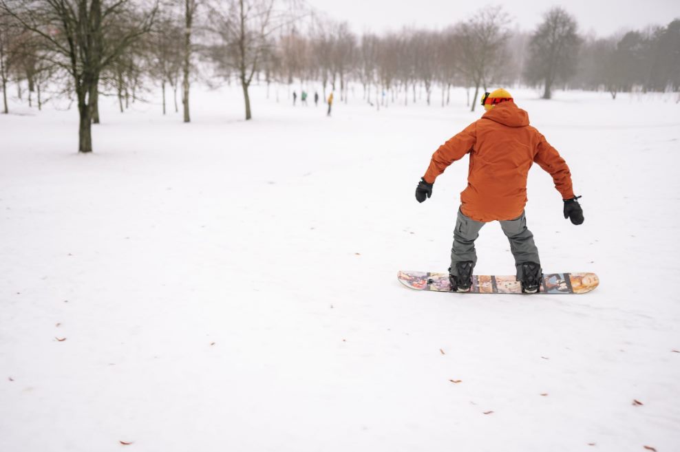 person in orange jacket snowboarding · free stock